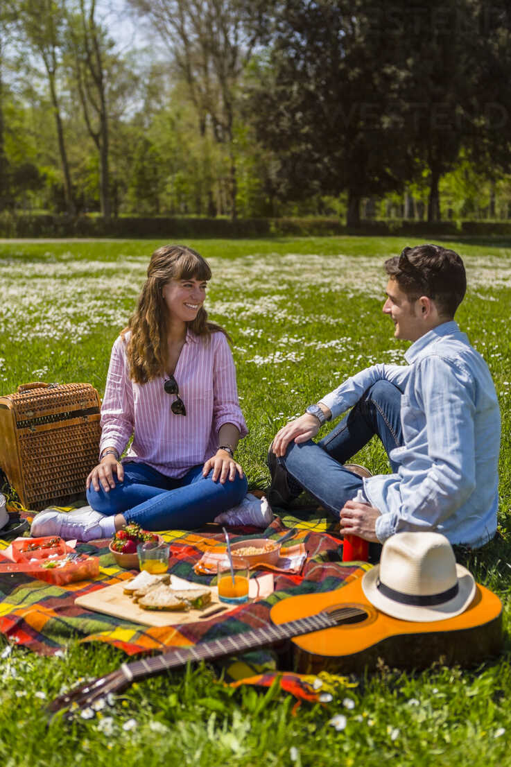 Young couple having a picnic with healthy food in a park stock photo
