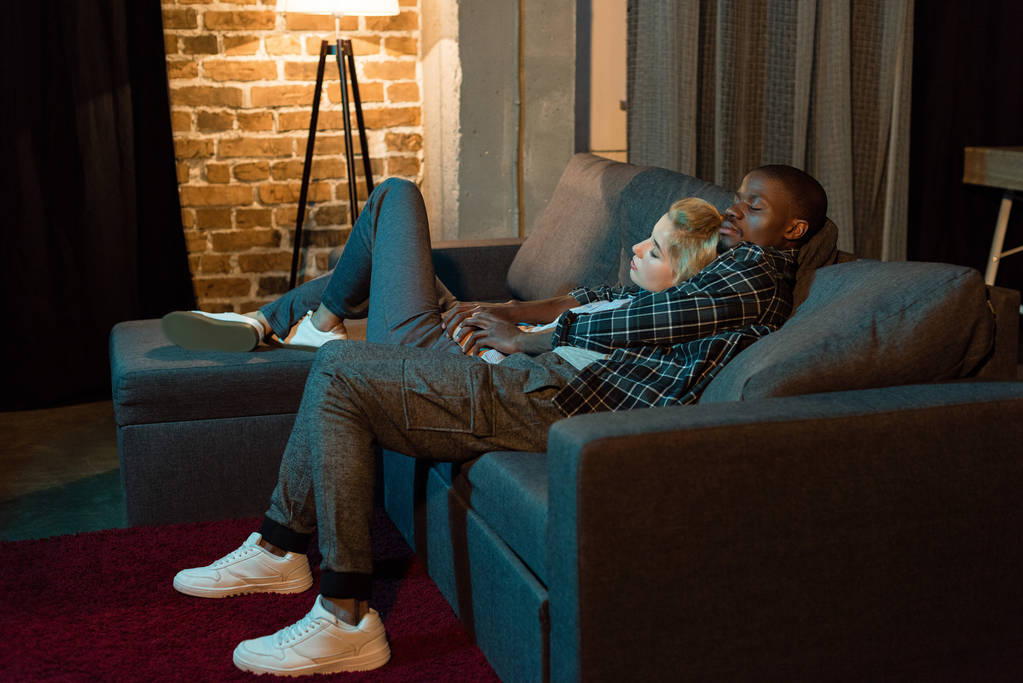 Multicultural Couple Sleeping On Sofa Together At Free Stock Photo and Image 174550580